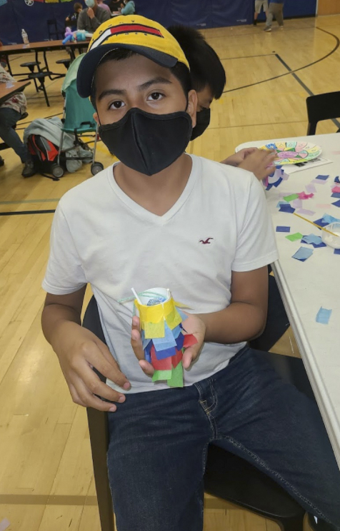 Student holding art project