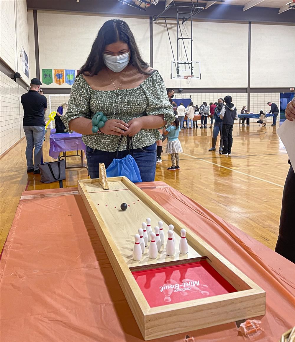 Teenage girl playing a bowling tabletop game