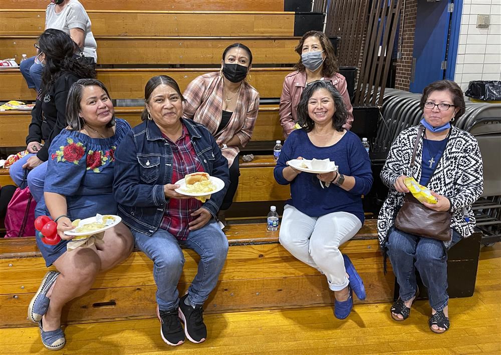 Group of women siting on bleachers posing for a photo