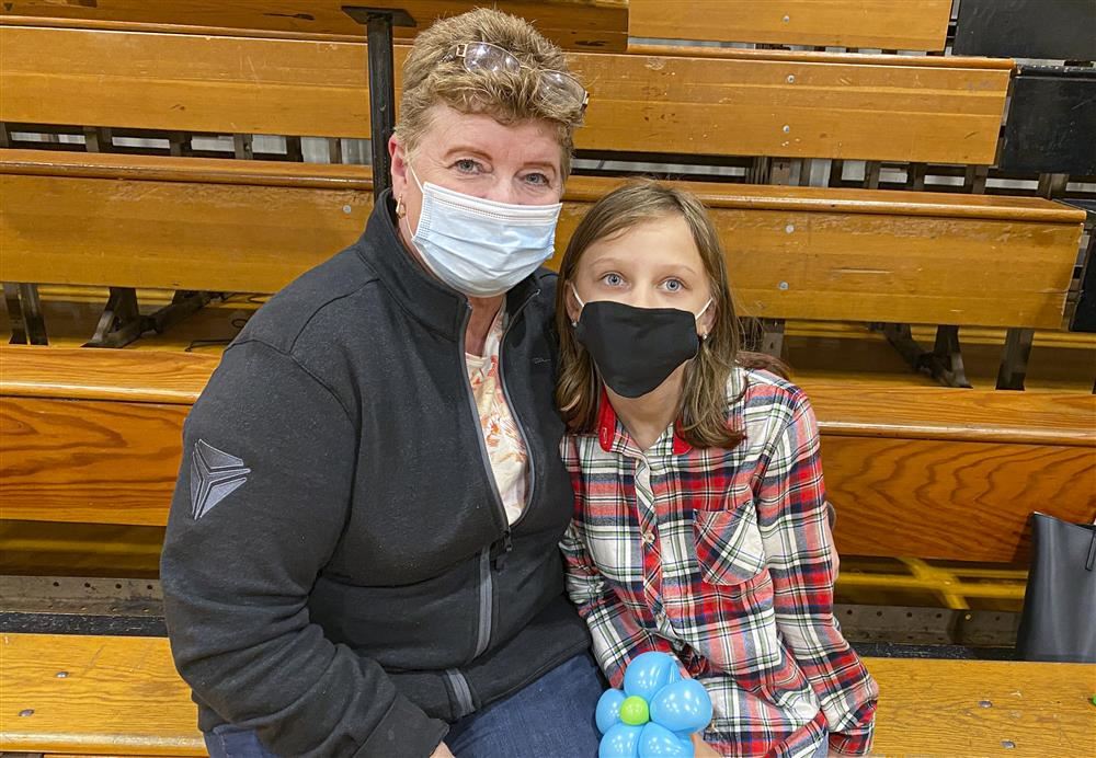 Mom and daughter sitting on bleachers posing for a photo