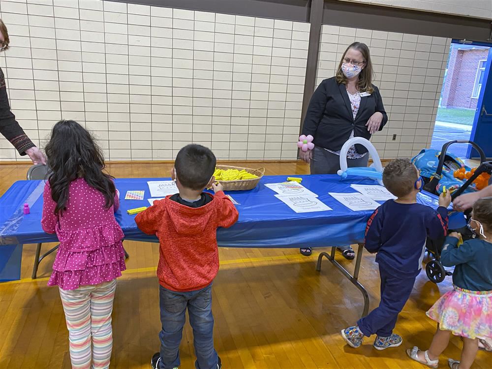 People and kids gathering around coloring table