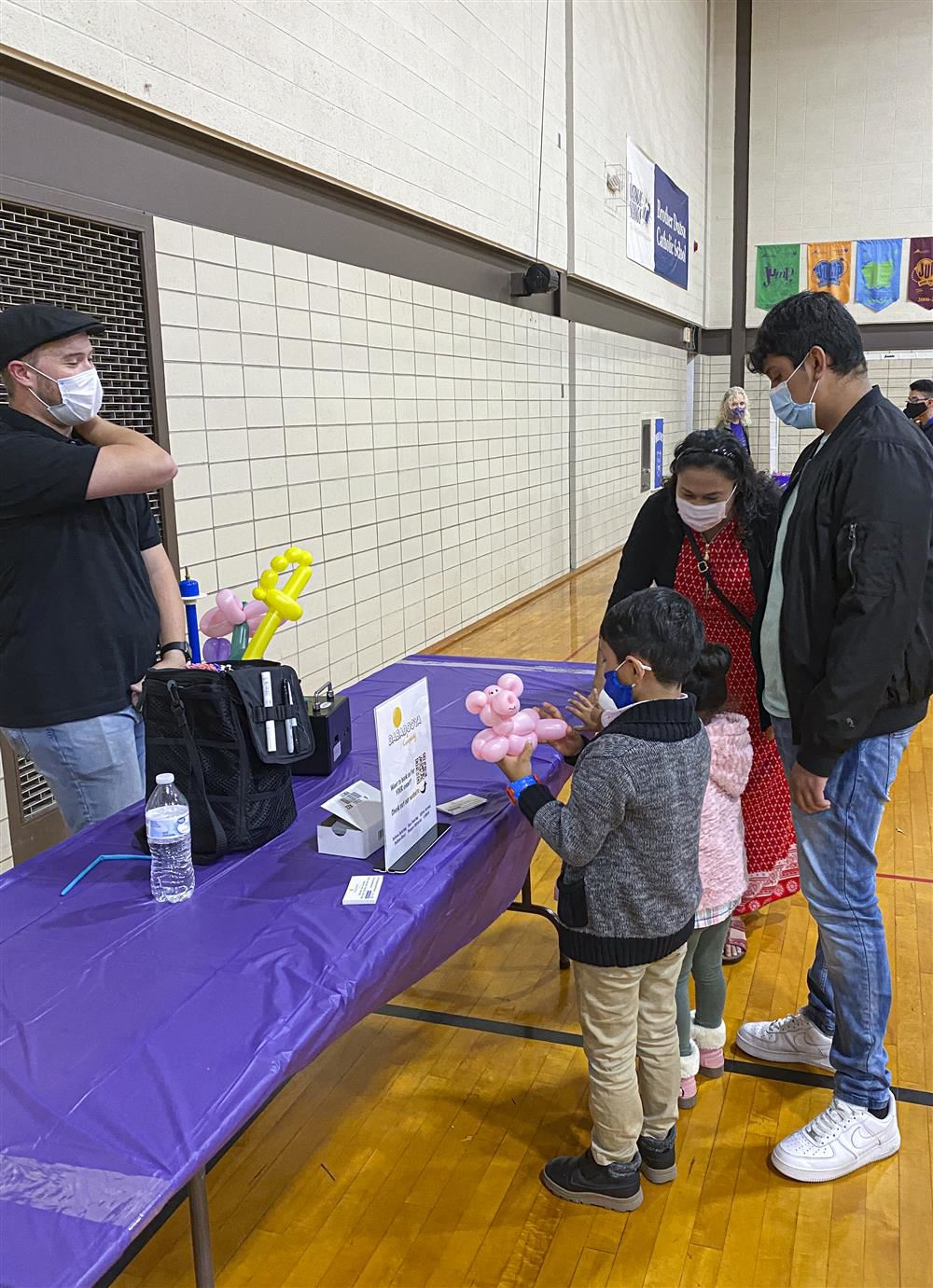 Family standing by a table looking at list of balloon figures