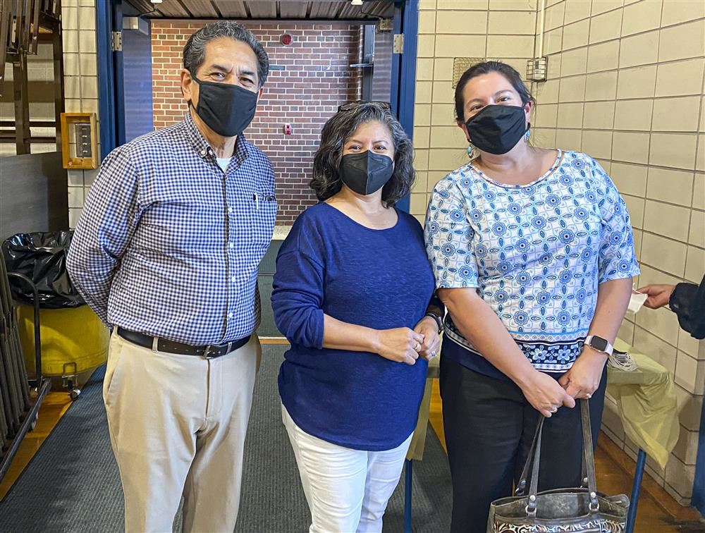Three adults standing together for a picture