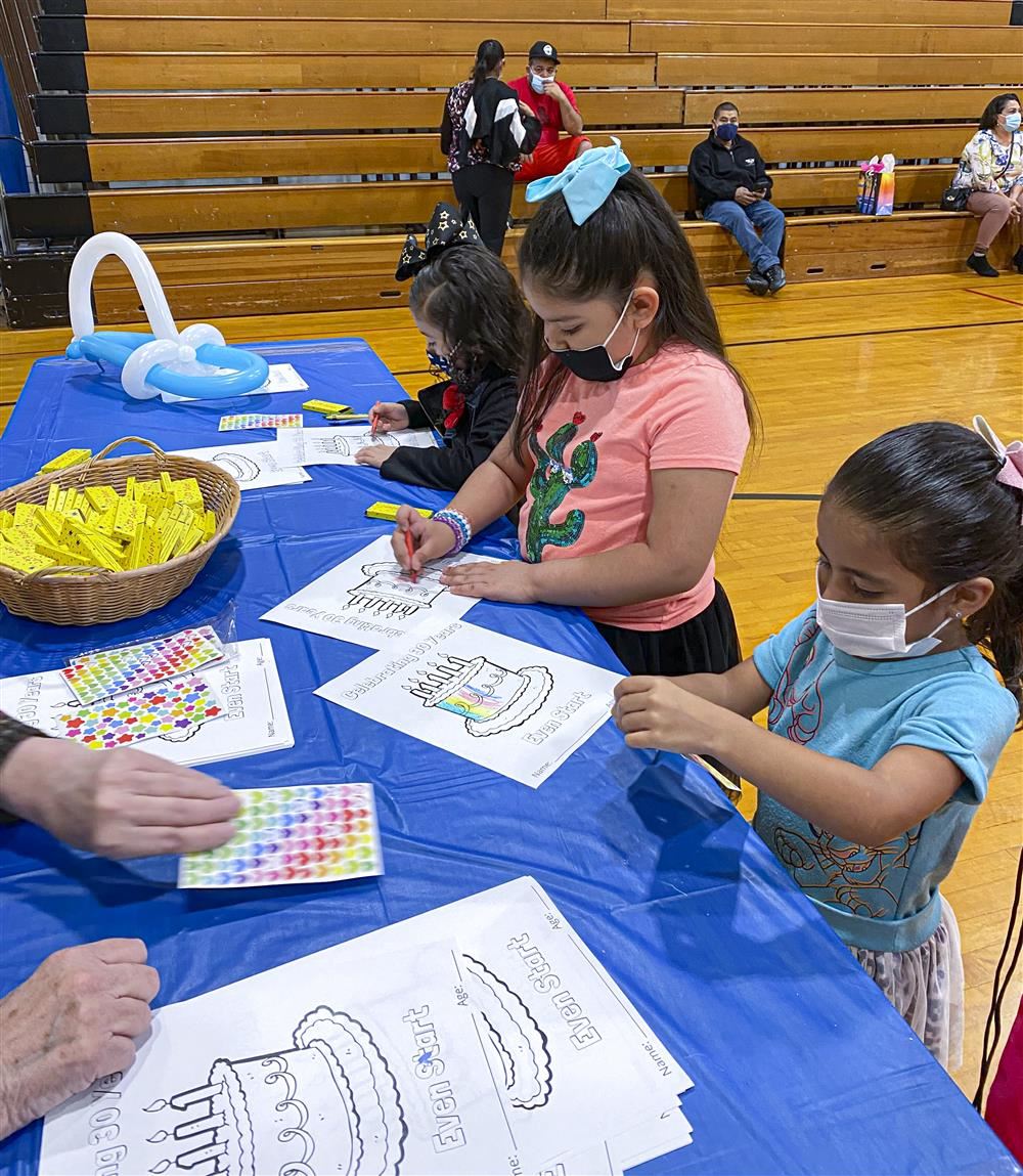 3 little girls coloring at a table