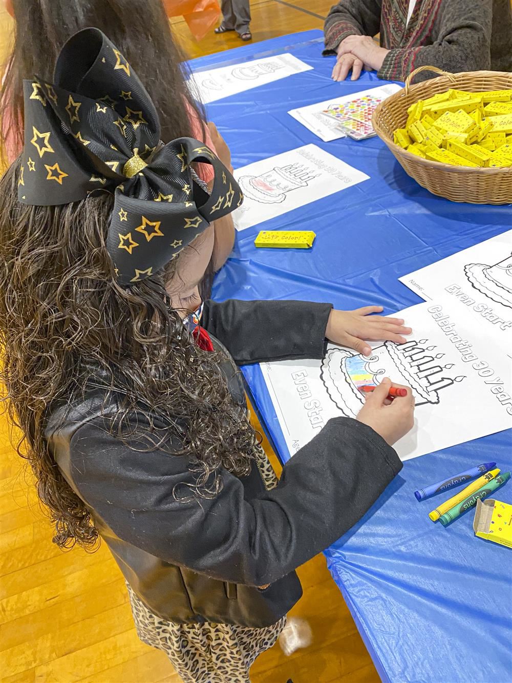 student coloring a sheet at a table
