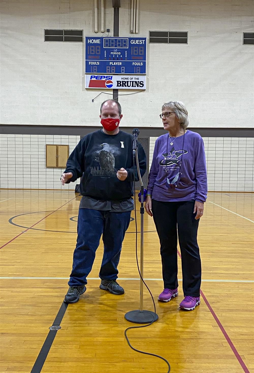 Two adults standing at microphone singing
