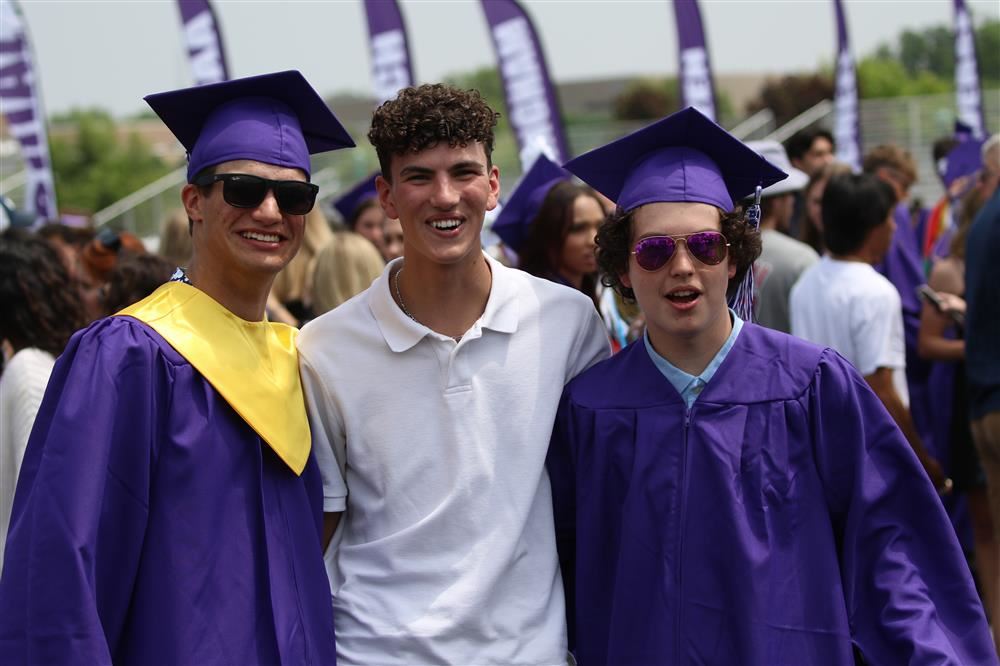 Graduation Picture - three young men smiling at the camera after graduating