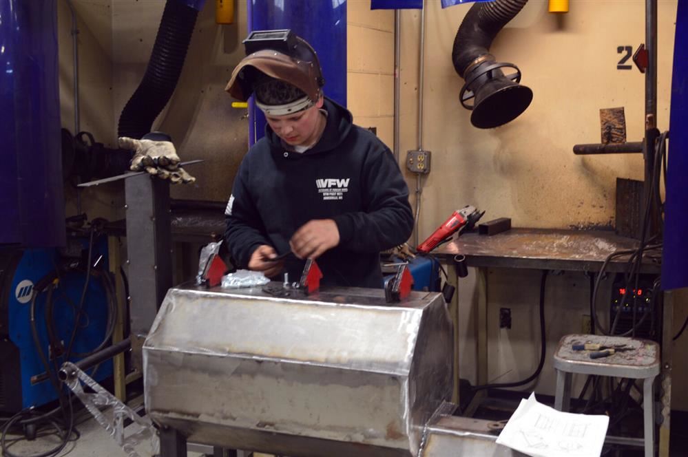 Rising senior Cole Mellom finishes the top of a smoker he created in a Beloit Memorial High School a